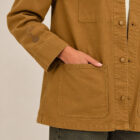 Veste bio femme couleur camel avec le dessin de la marque représentant un arbre sur la planète et un homme qui grimpe à l'arbre, sérigraphie de couleur marron. Vue de face et zoom sur la veste et sa manche.